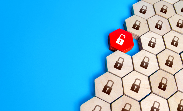 A red unlocked padlock among many locked blocks symbolizing a potential data leak