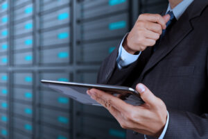 Businessman using tablet in data center, representing data augmentation in technology